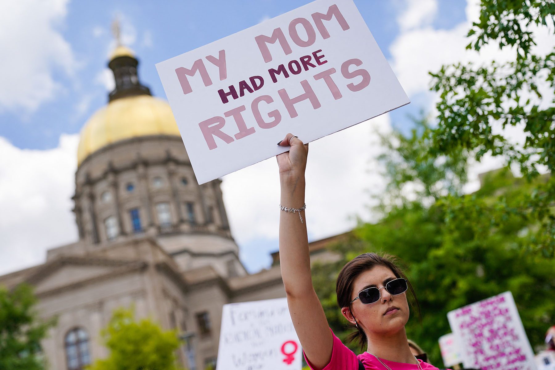 A demonstrator holding a sign that reads "My Mom Had More Rights" protests in front of the georgia supreme court.
