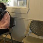 A woman sits in a chair in an abortion clinic waiting room.