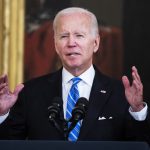 President Biden speaks in front of a microphone