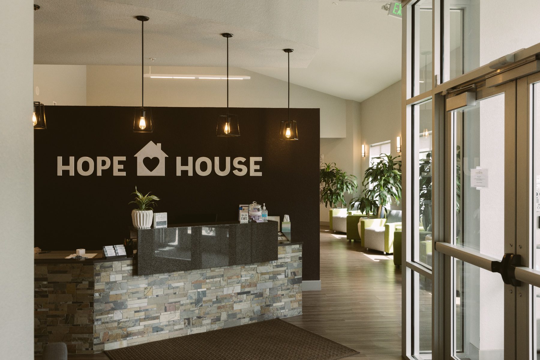 A building lobby with the words "Hope House" on a wall behind a desk.