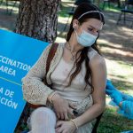 A Medical Reserve Corps volunteer administers a monkeypox vaccination to a Los Angeles resident in a park.