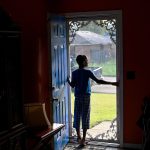 A boy peers out of his front door in Jackson, Mississippi.