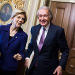 Sens. Ed Markey and Elizabeth Warren smile while speaking to each other on Capitol Hill.