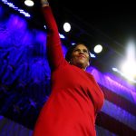 Secretary of State candidate Tanisha Sullivan greets delegates from a stage.