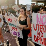 Abortion rights protesters hold signs that read 