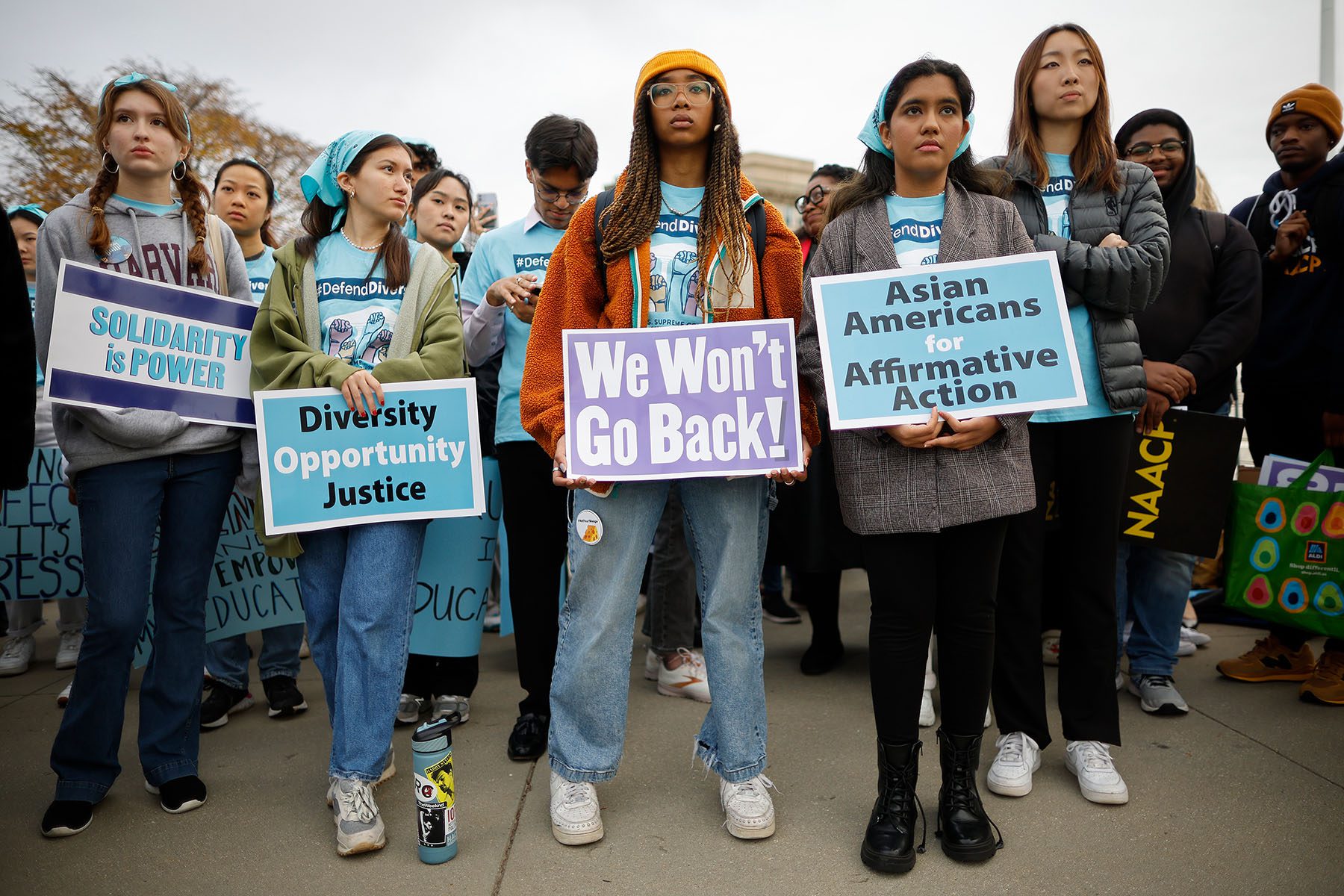 Proponents for affirmative action in higher education hold signs that read "we wont go back!" "Diversity, opportunity, justice," "Asian Americans for Affirmative Action," and "Solidarity is power" in front of the Supreme Court.