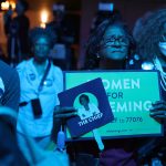 A Demings supporter holds a sign that reads 