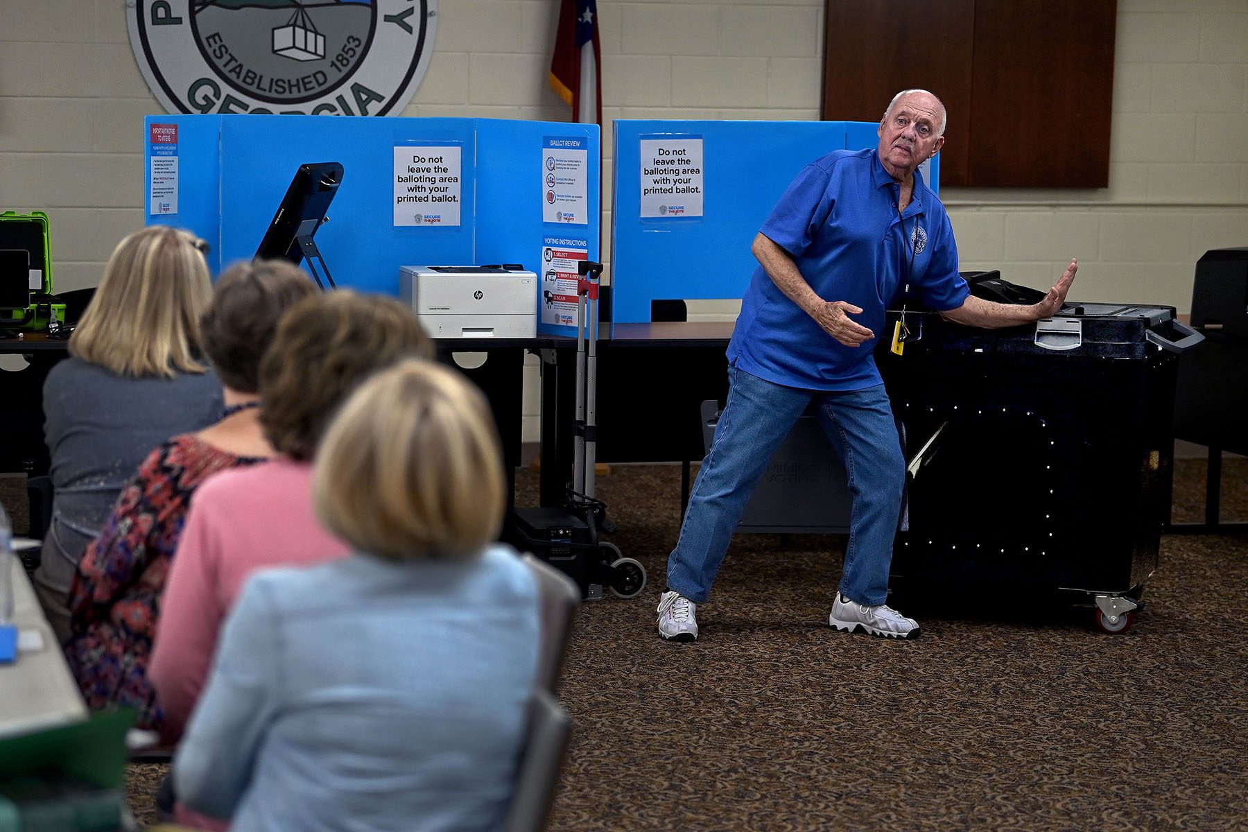 An IT expert for Georgia Votes trains prospective poll workers on how to use the Dominion voting machine.