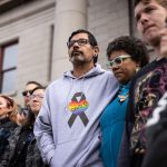 Mourners outside of the Colorado Springs City Hall where a rainbow flag was draped over the building.