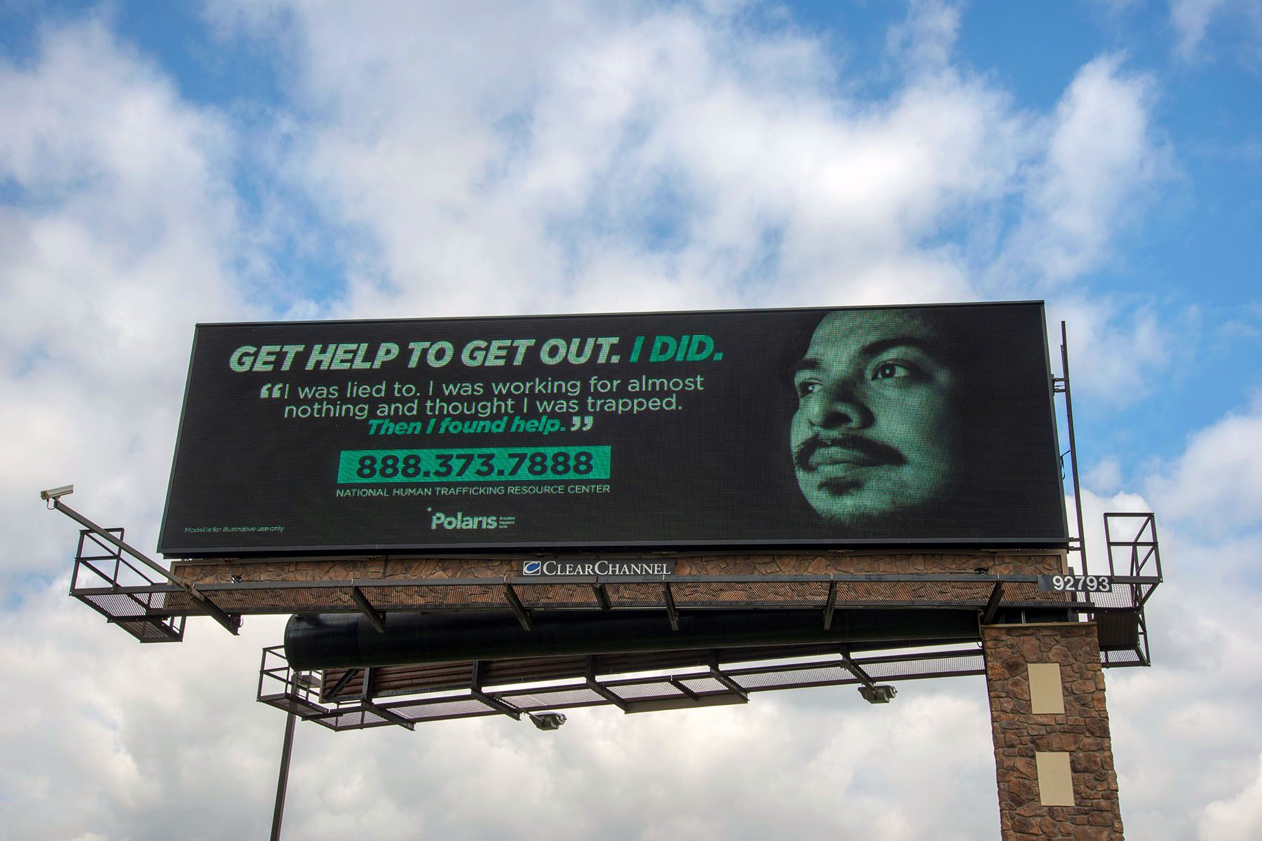 An anti-trafficking billboard reads "Get help to get out. I did." A quote by a survivor reads "I was lied to. I was working for almost nothing and thought I was trapped. Then I found help." The number for the hotline, 888.373.7888, is listed at the bottom of the billboard.