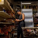 A woman restocks shelves at her business.