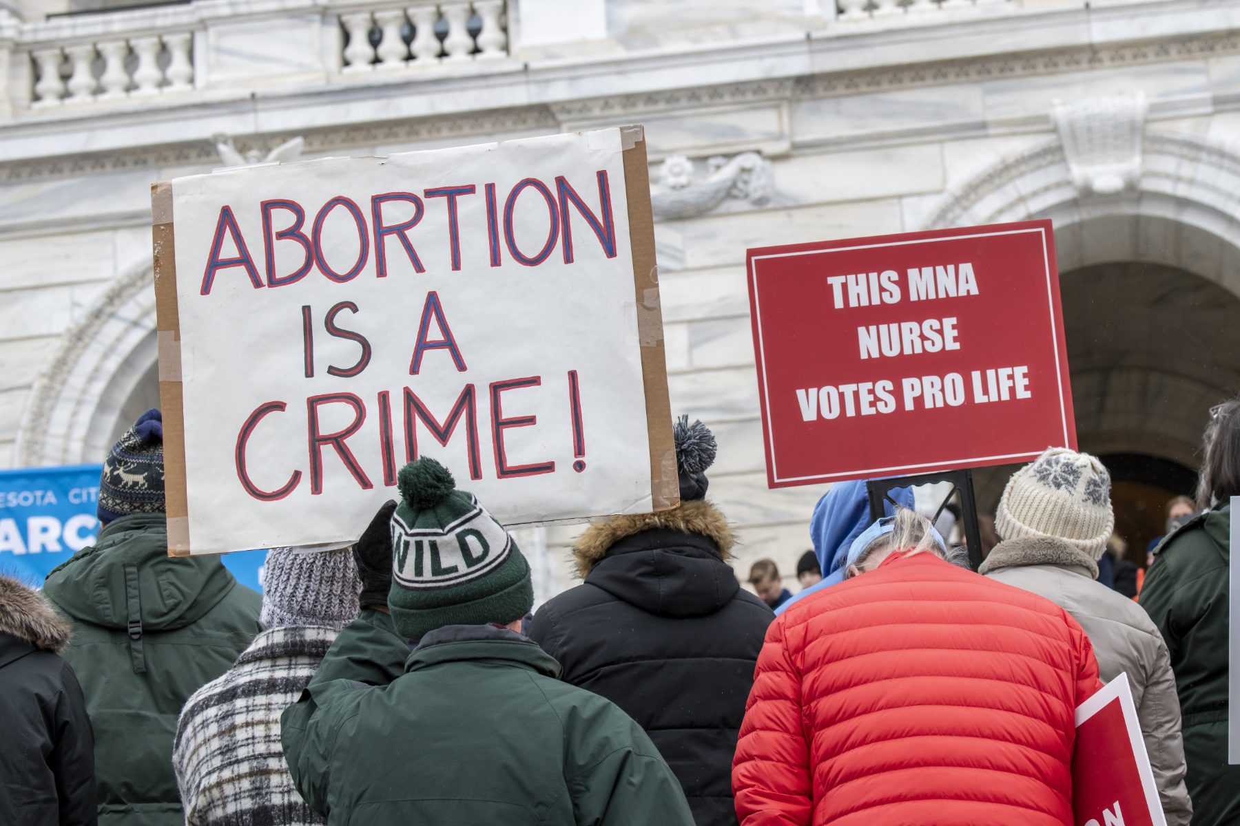 Anti-abortion protesters hold a sign that reads "ABORTION IS A CRIME!"