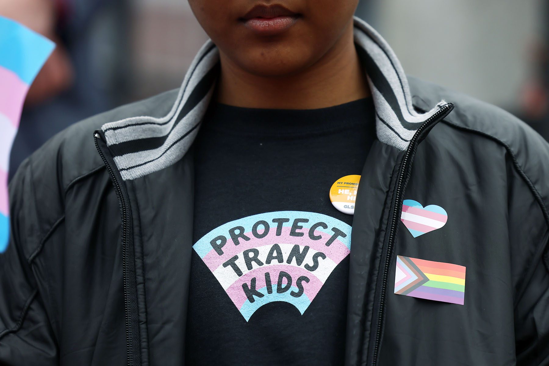 A person wearing a "protect trans kids" shirt takes part in a rally during a Transgender Day of Visibility event.