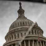 The dome of the U.S. Capitol is reflected on a broken piece of tile.