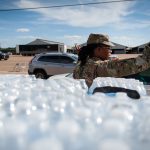 A National Guard directs traffic at a water distribution site at the Mississippi State Fairgrounds.