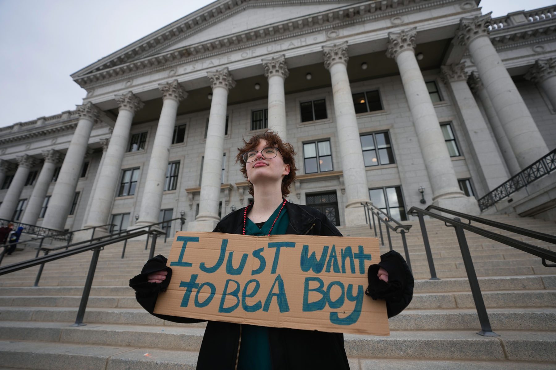 A protester holds a sign that reads "I just want to be a boy" following a rally in front of the Utah State Capitol.