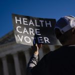 A supporter of the Affordable Care Act holds a sign that reads 