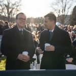 Chasten and Pete Buttigieg stand outside with crowds in the background