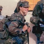 Photo of Christina Schauer and fellow soldiers dressed in uniform line up to receive equipment at Camp Virginia in Kuwait.