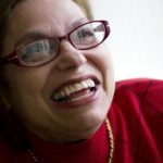 Judy Heumann smiles as she poses for a portrait.