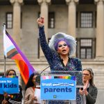 Drag artist Vidalia Anne Gentry raises her fist as she speaks during a news conference in front of the Tennessee Capitol.