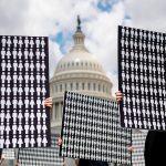 Demonstrators hold up placards representing the number of the people who have died due to gun violence during an event with gun violence prevention advocates on Capitol Hill.