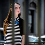 Transwoman Rep. Zooey Zephyr pictured behind fence on the steps of the Montana State Capitol during ally.