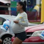 A pregnant woman in Puerto Rico picks up cleaning supplies after Hurricane Maria