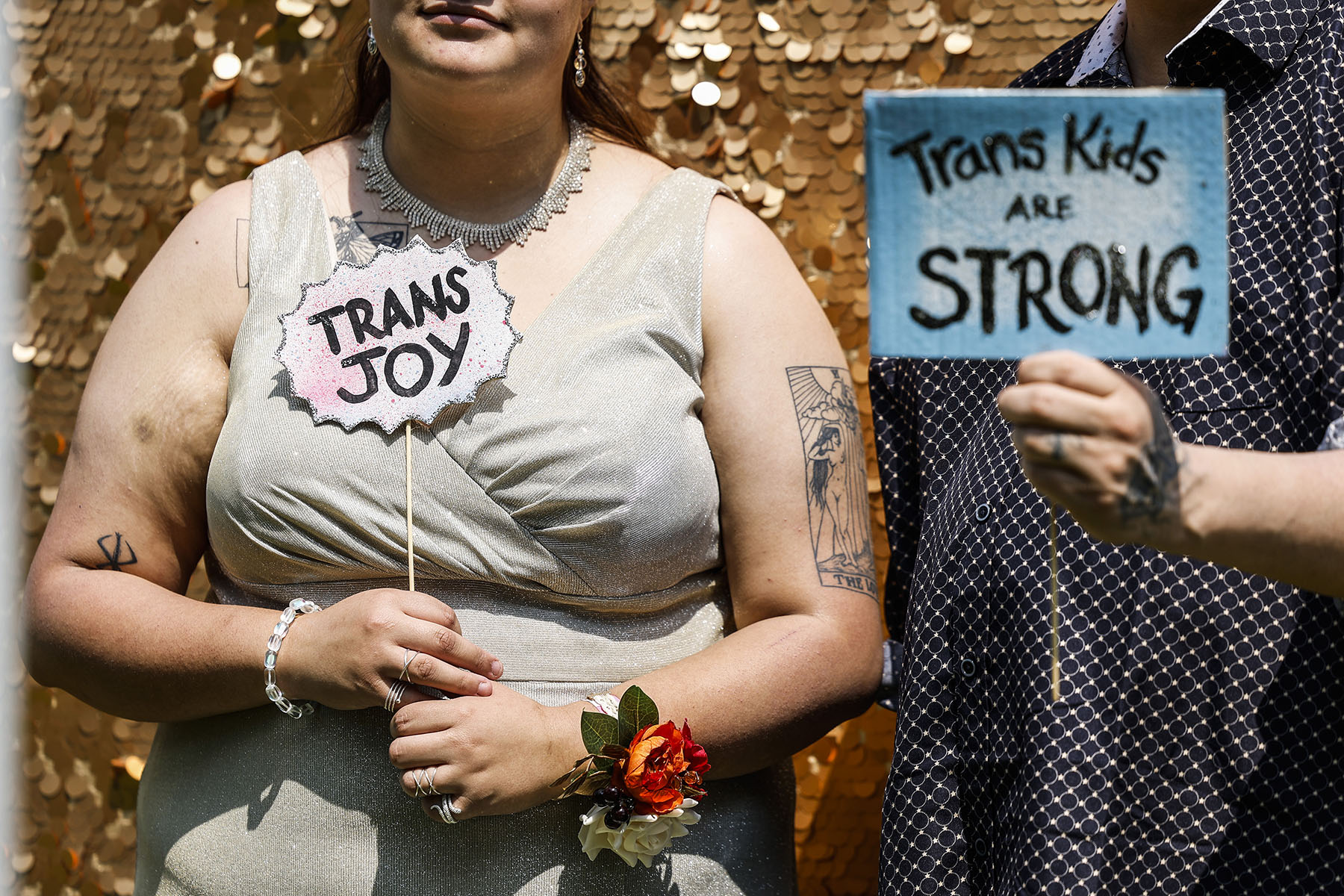 People hold up signs as they have their picture taken at a photo booth during a "Trans Youth Prom" event on Capitol Hill.