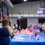 Daniel Cameron speaks at a podium in front of an audience.