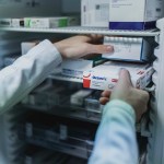 A pharmacists takes an Ozempic package out of a pharmacy fridge.