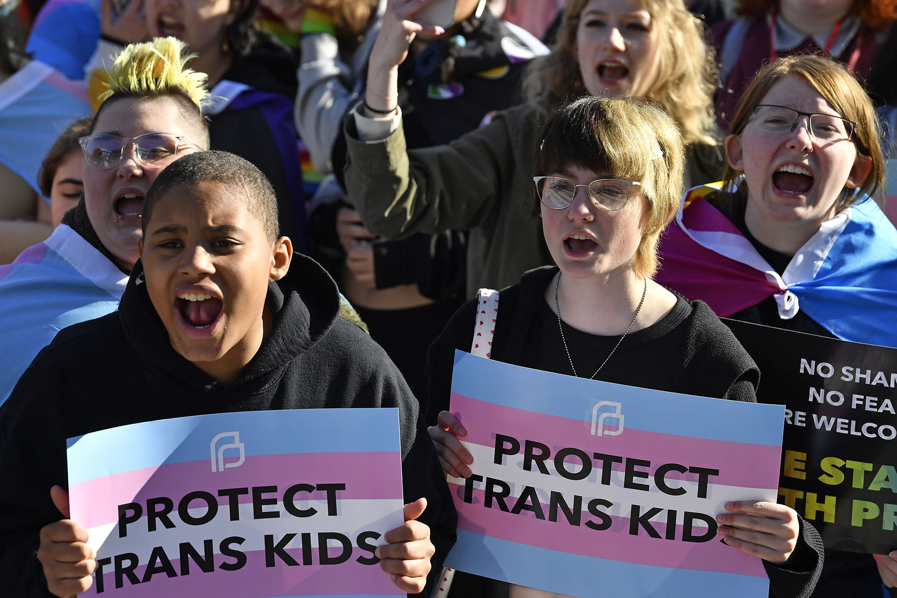 Protesters of Kentucky Senate Bill SB150 cheer and hold signs that read "Protect Trans Kids"