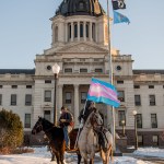 Two Native riders are seen on the South Dakota Capitol lawn on horseback.