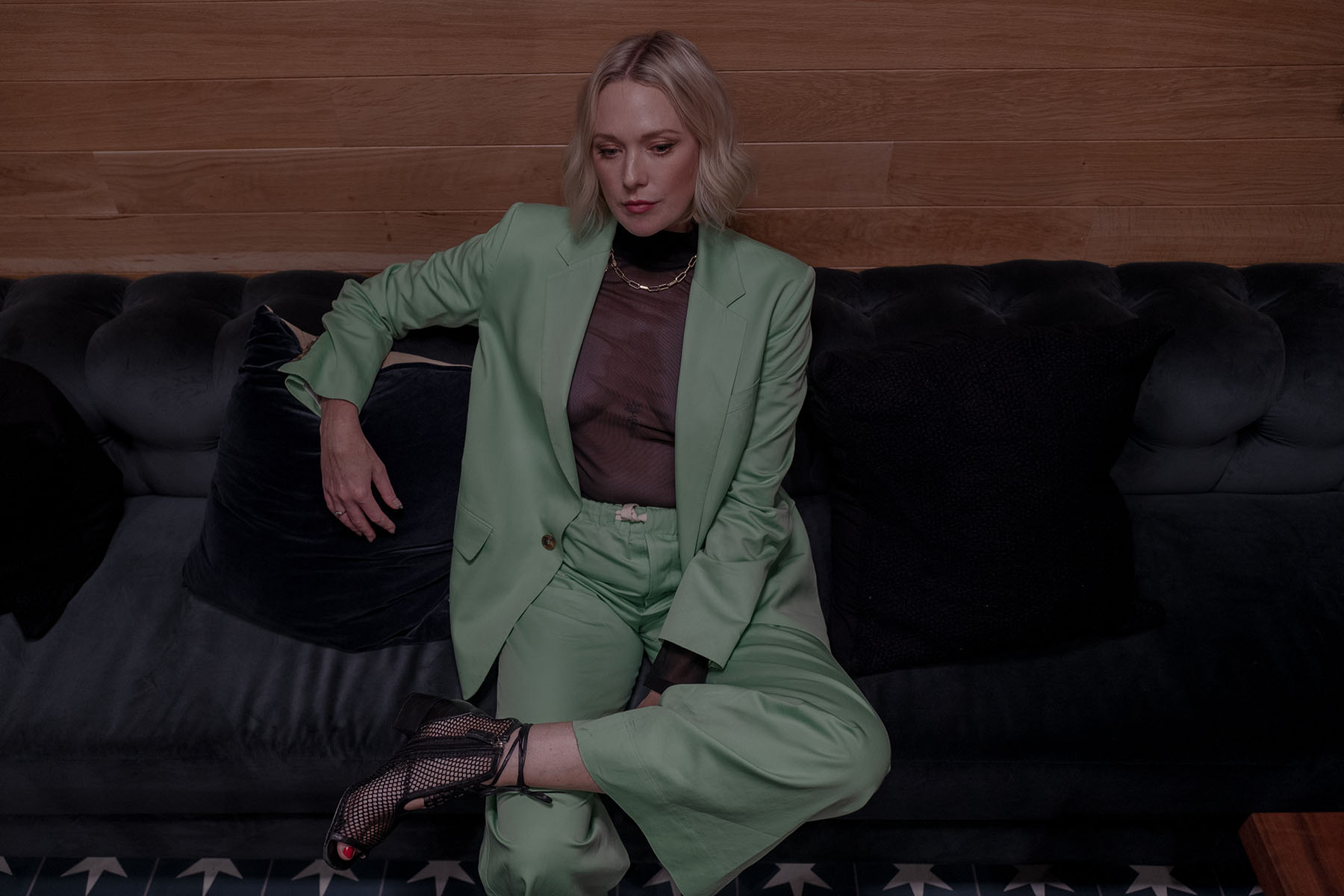 Haely White sits on a couch and looks down as she poses for a portrait.