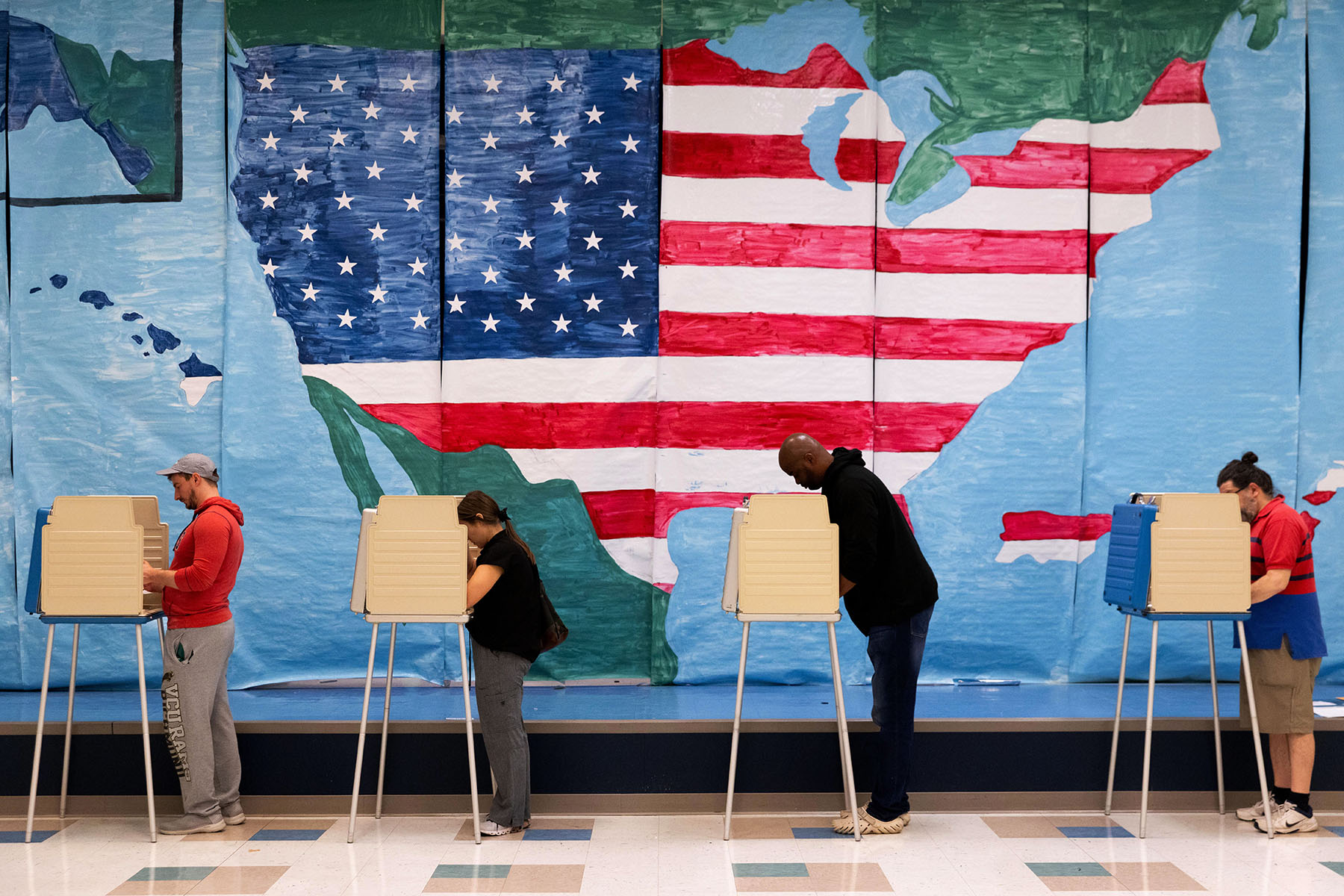 Voters fill out their ballots in front of a giant map of the United States at a polling station on November 7, 2023.