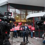 Ron DeSantis stands outside a building surrounded by camers