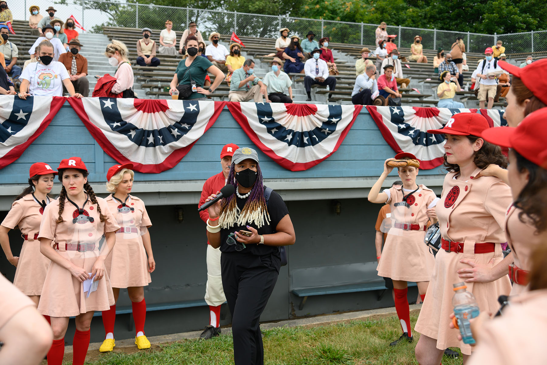 Ayoka Chenzira speaks to people on set through a microphone on the set of A League of Their Own.