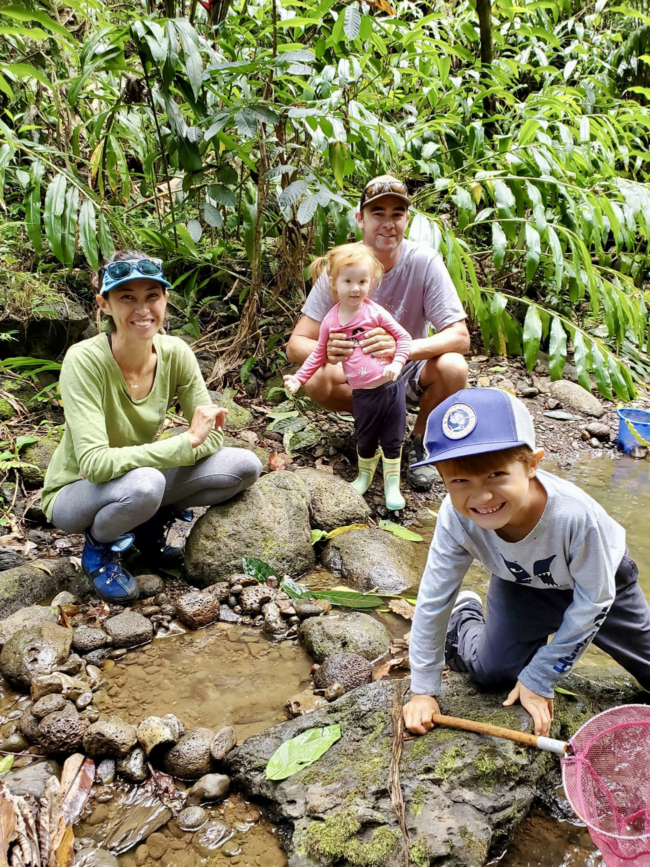 Cynthia King, her two children and her husband pose and smile while hiking in Hawaii.