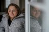 Emily Voorde is seen reflected in a window as she sits for a portrait.