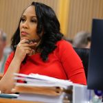 Fulton County District Attorney Fani Willis listens during arguments in a courtroom.