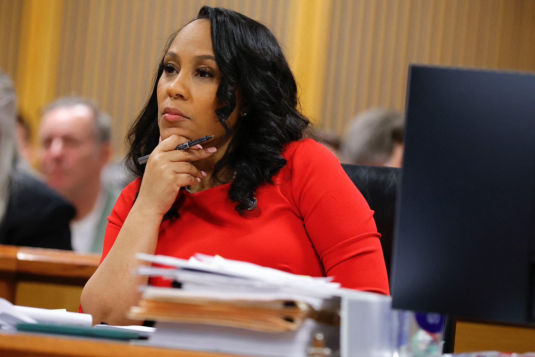 Fulton County District Attorney Fani Willis listens during arguments in a courtroom.