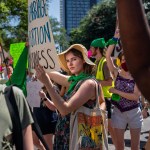 A woman holding a sign looks straight into the camera as abortion rights activists and supporters march outside of the Austin Convention Center, in May 2022.