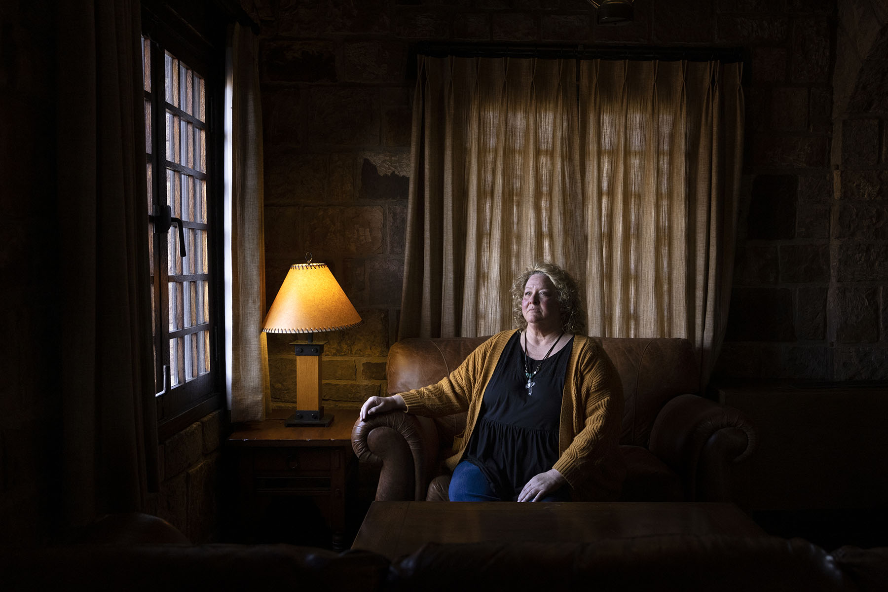 Cheryl Thompson sits for a portrait near a window.