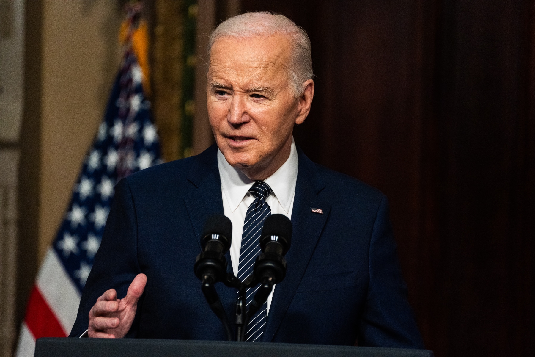 President Joe Biden speaks in front of microphones