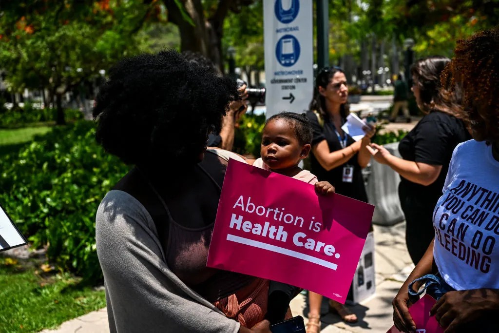 A black woman holds a child during an abortion rights protest in Florida.