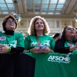 People listen as President Joe Biden delivers remarks on proposed spending on child care and other investments in the 