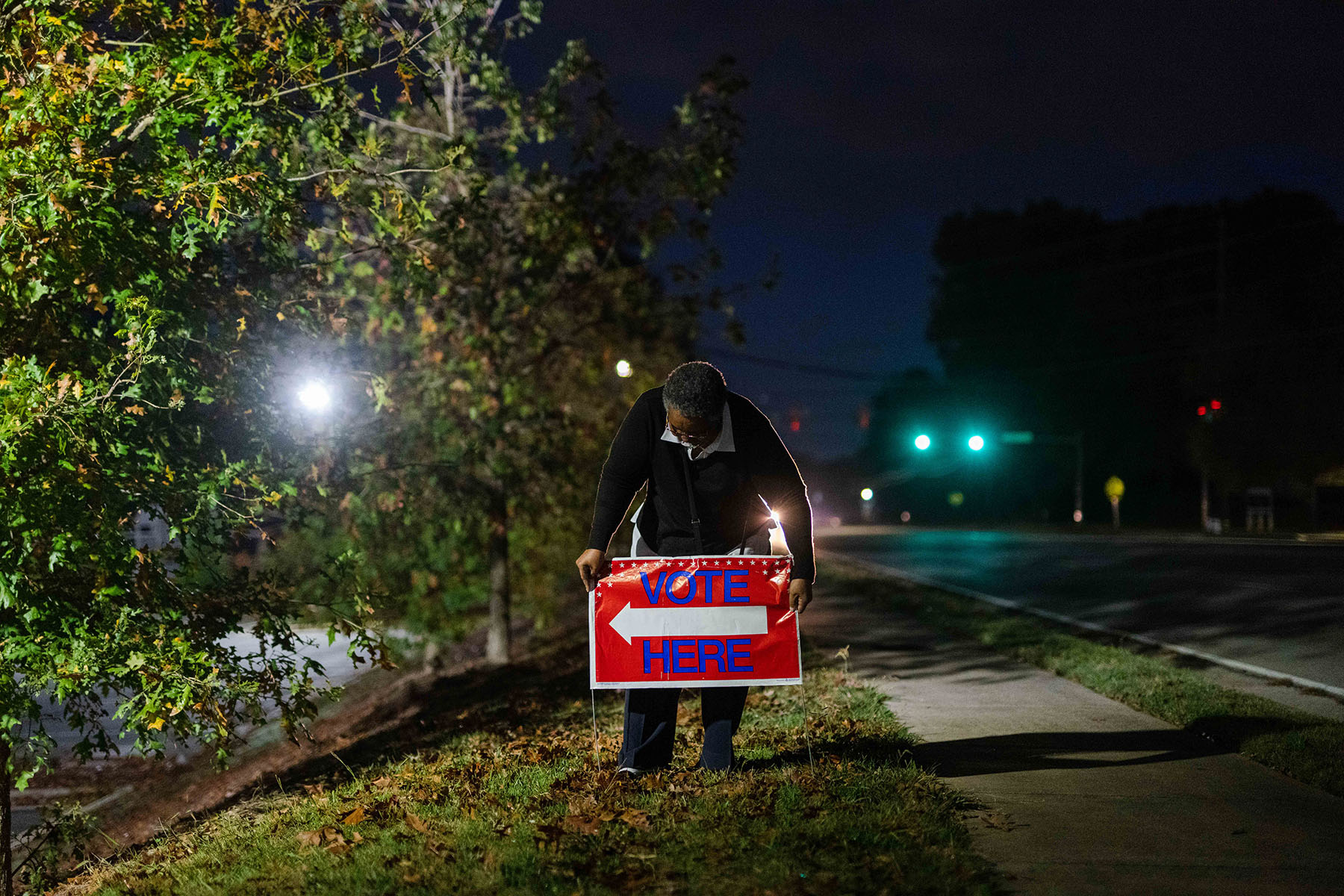 A first time poll worker puts out a "Vote Here" sign near a church in Marietta, Georgia.