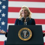 First Lady Jill Biden delivers remarks from a podium. Behind her is an American flag.