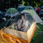 Juan looks out from inside his tent at the GWU encampment.