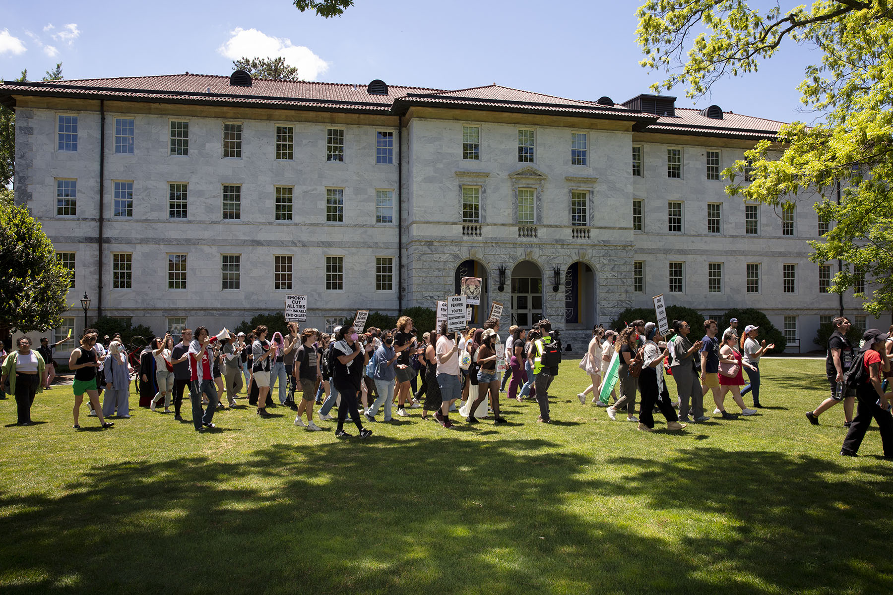 Emory students and community members march to the quad at Emory while chanting and holding signs.